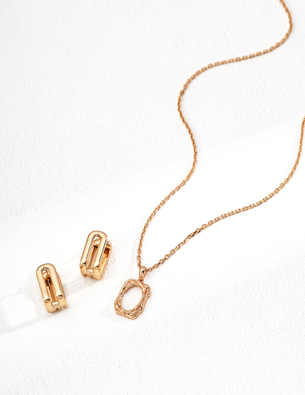 Rose gold necklace and clips on a white background