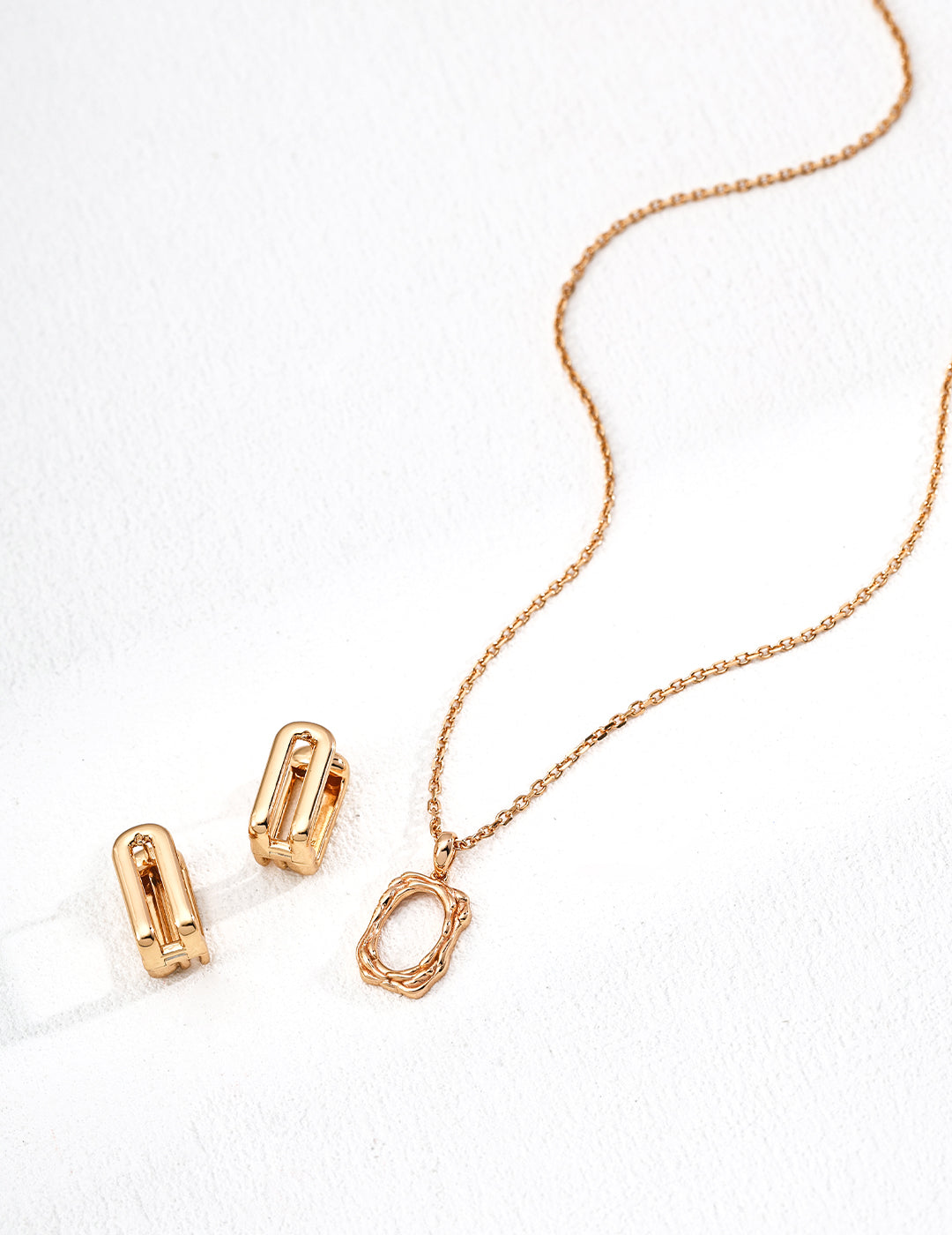 Rose gold necklace and clips on a white background