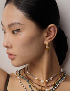 Tiger's Eye earrings in natural sunlight, showcasing their chatoyancy and golden brown hues on model.