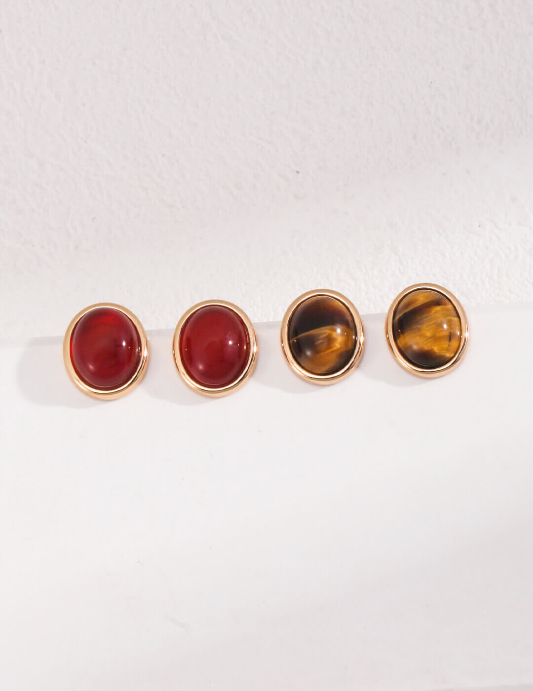 Front view of tiger's eye and onyx stud earrings in vintage gold S925 silver.