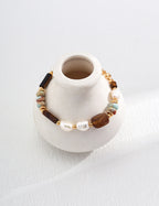 Bracelet with beads on a white vase against a white background