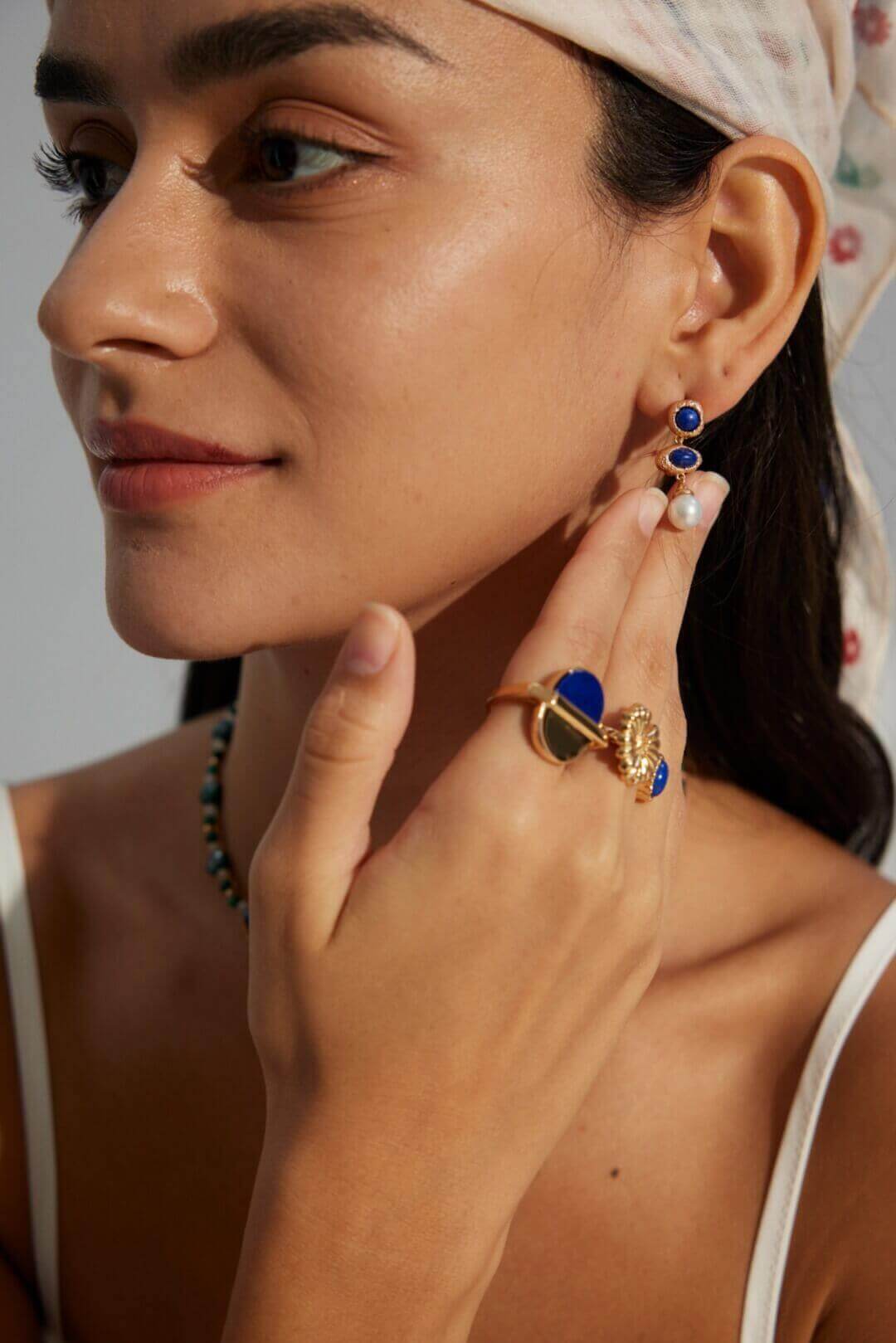 Universal appeal pearl and lapis lazuli earrings complementing various skin tones with warm gold finish.
