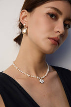 Versatile enamel rose and pearl necklace styled with various necklines, from crew to V-neck.