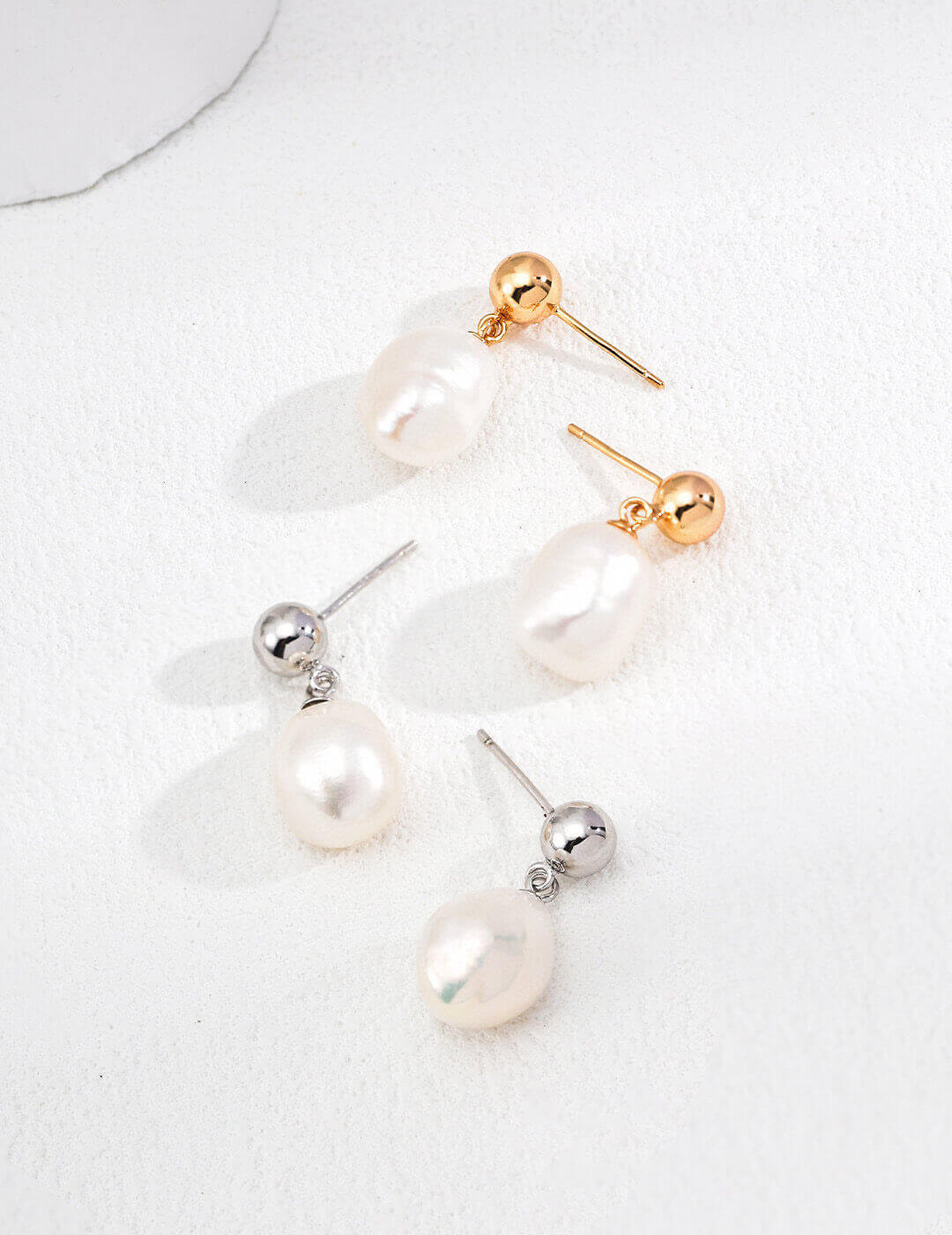 Vintage baroque natural pearl earrings in 925 sterling silver with a gold tone accent, showcasing their unique shape and elegance.