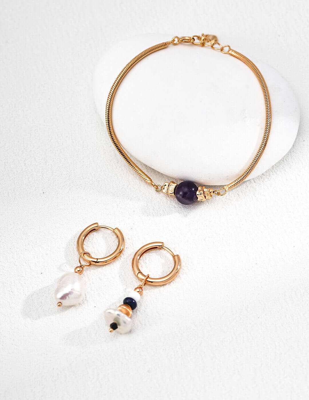 Detailed close-up of the 8mm smooth amethyst bead and gold spacers.