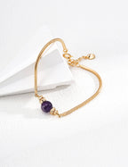 The amethyst bracelet laid flat on a neutral background.