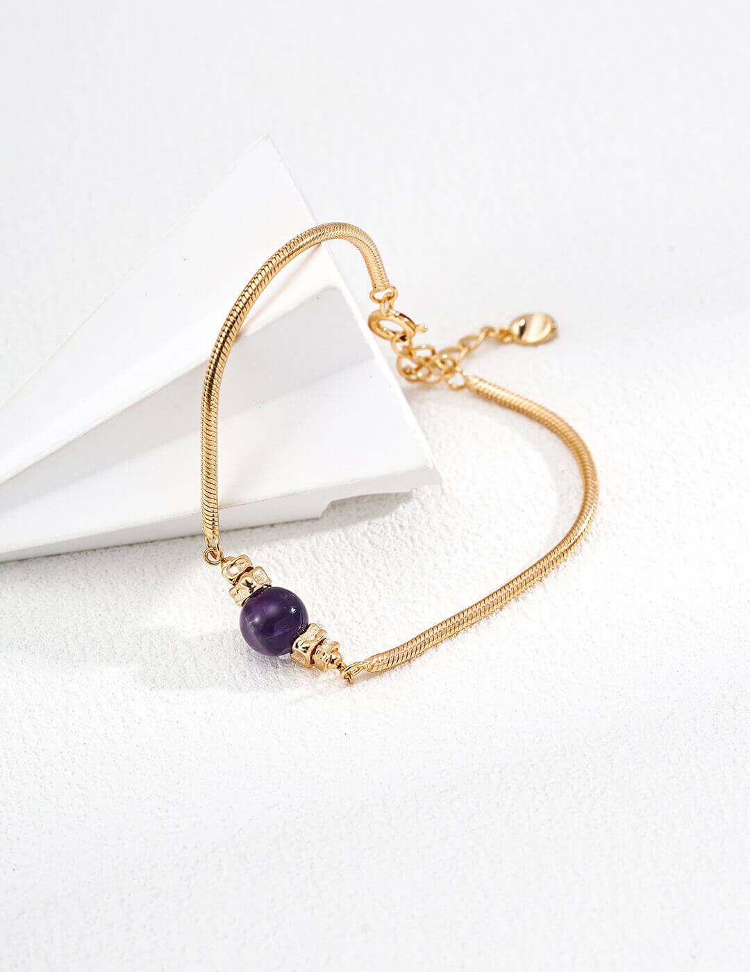 The amethyst bracelet laid flat on a neutral background.