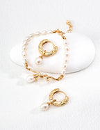 Gold hoop earrings with pearls on a white background
