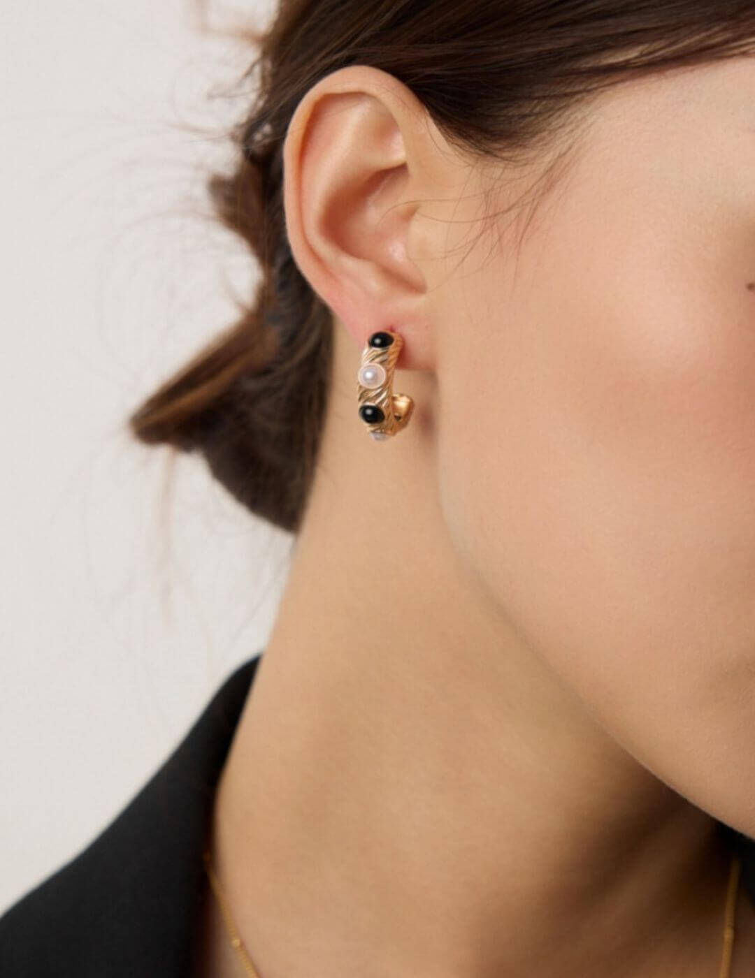 Side view of vintage gold pearl and onyx stud earrings on model, showcasing refined sophistication.