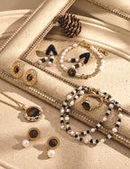 Jewelry set including earrings and a bracelet on a textured surface