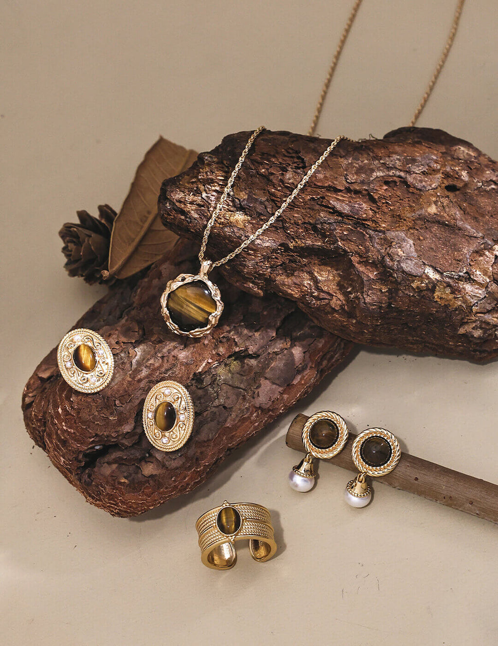 Gold jewelry set including necklace, earrings, and ring on a wooden surface.