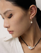 A smiling model wearing the nature-inspired pearl earrings, reflecting the warmth and beauty of the design.