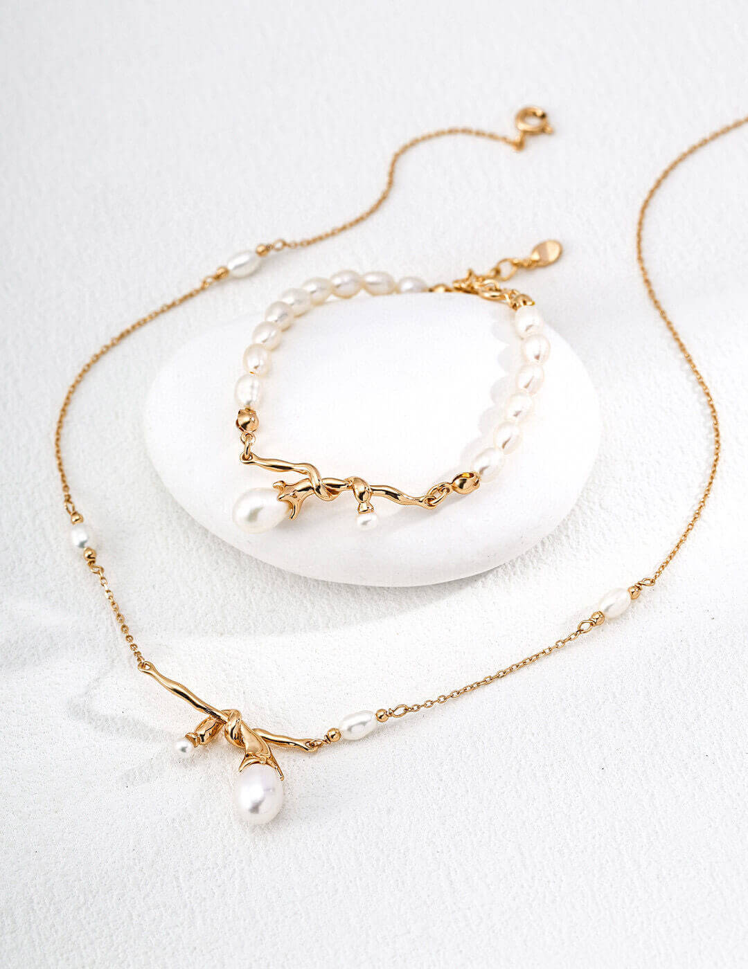 Gold necklace with pearl accents on a white background