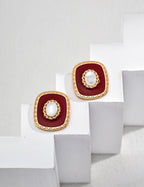 Minimalist white shell and red enamel drop earrings in 925 sterling silver on a white background.