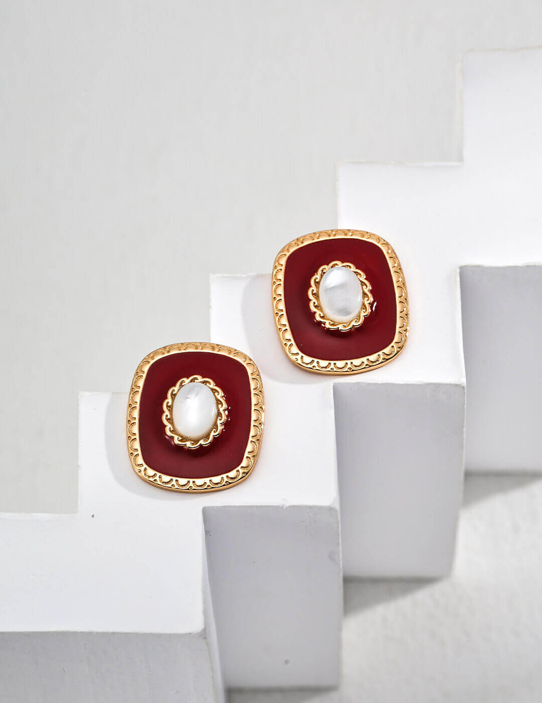 Minimalist white shell and red enamel drop earrings in 925 sterling silver on a white background.